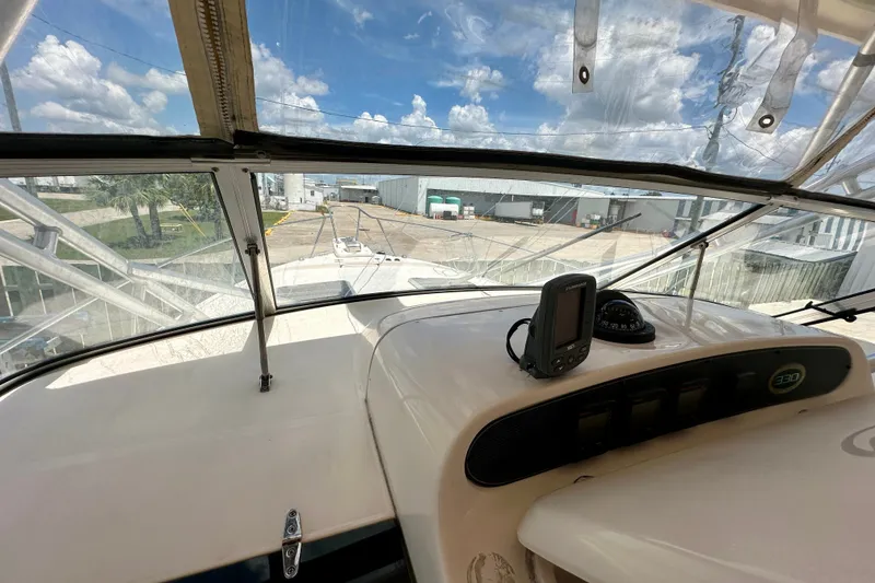 Slide: The Image of 2007 Grady-White Express 330 boat cockpit with navigation equipment and clear canopy view. - 71