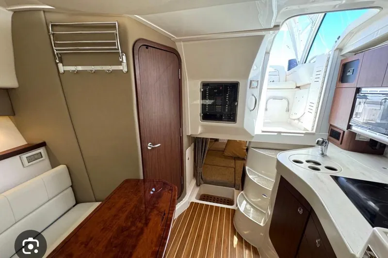 Slide: The Image of Interior of a 2007 Grady-White Express 330 boat, featuring a cozy cabin and kitchenette. - 14