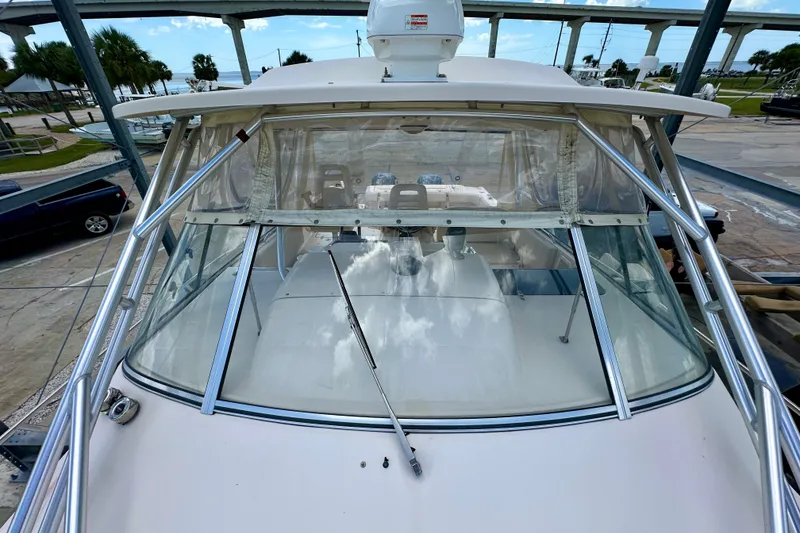 Slide: The Image of 2007 Grady-White Express 330 boat with clear windshield and metal frame, docked near a bridge. - 35