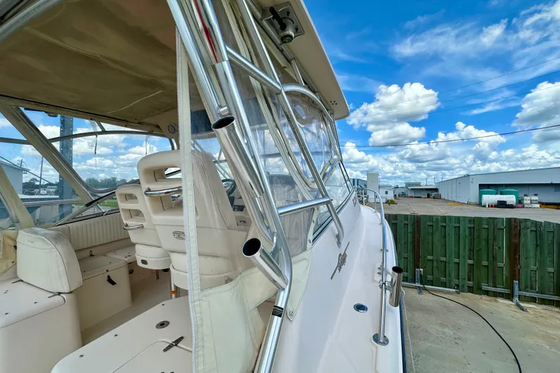 Slide: The Image of 2007 Grady-White Express 330 boat interior with seating, docked under a blue sky. - 42