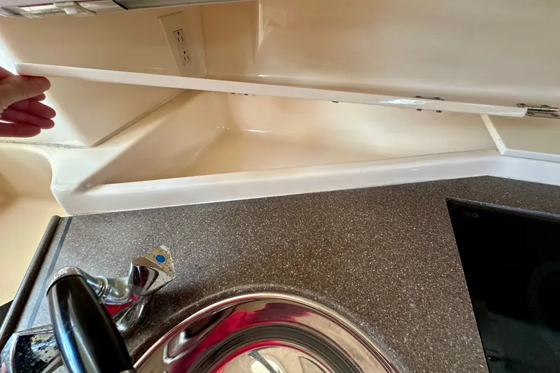 Slide: The Image of 2007 Grady-White Express 330 boat interior with sink and storage compartment. - 98