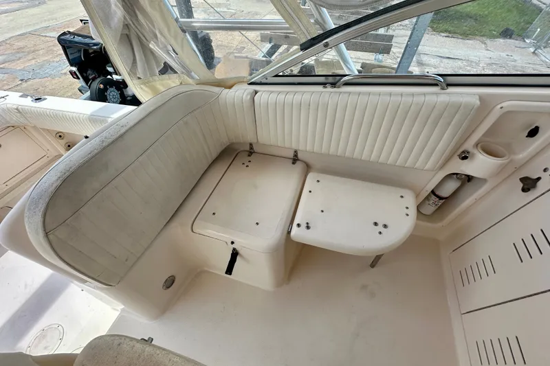 Slide: The Image of 2007 Grady-White Express 330 boat interior with white seating and storage compartments. - 58