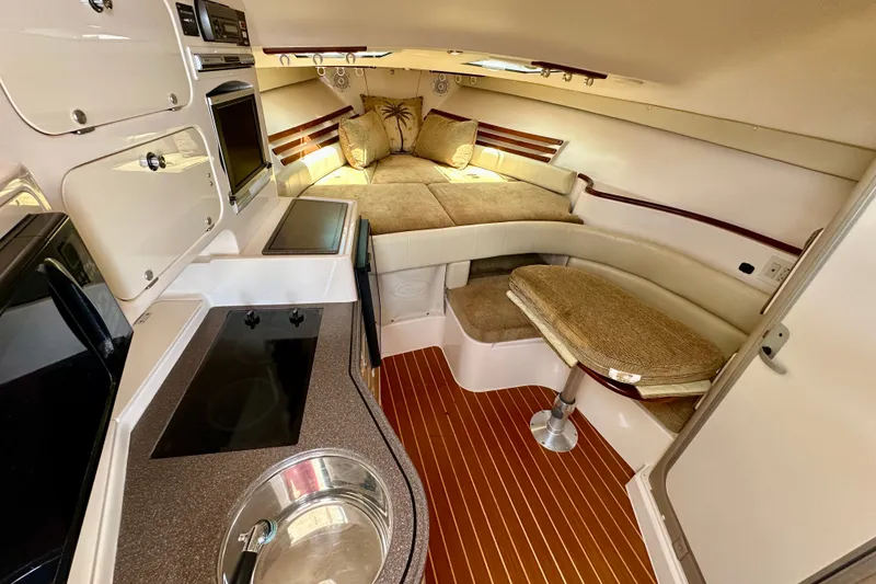 Slide: The Image of 2007 Grady-White Express 330 cabin interior with kitchenette, seating, and cozy sleeping area. - 19