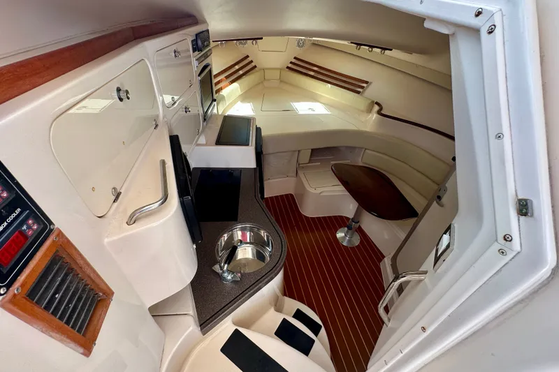 Slide: The Image of 2007 Grady-White Express 330 cabin interior with seating, kitchenette, and wood accents. - 74