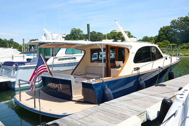 The Image of 2027 Palm Beach 42 yacht docked, featuring elegant design and American flag. - 5