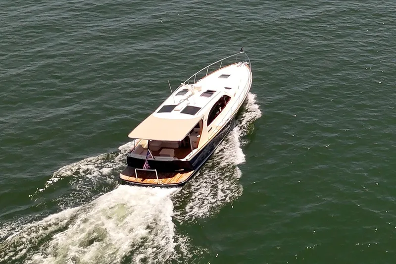 Slide: The Image of 2027 Palm Beach Motor Yachts PB42 cruising on open water, aerial view. - 2