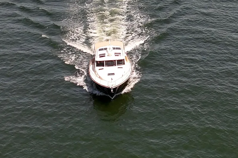 Slide: The Image of 2027 Palm Beach Motor Yachts PB42 cruising on open water, aerial view. - 4