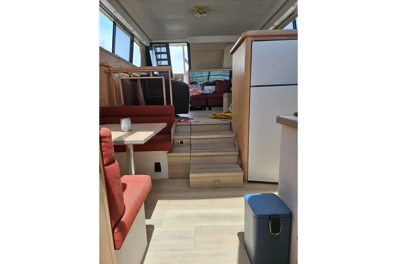 Slide: The Image of Interior of 1993 Silverton 46 Motor Yacht with red seating, table, and stairs. - 25