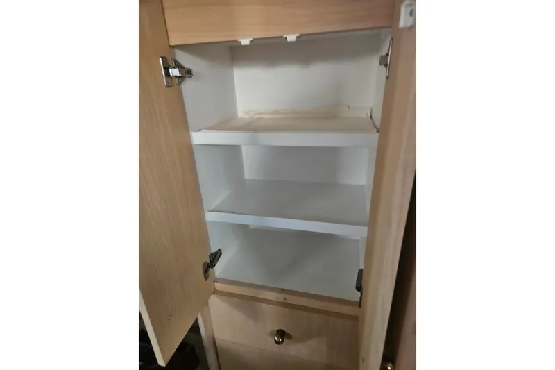 Slide: The Image of Empty wooden cabinet with shelves inside a 1993 Silverton 46 Motor Yacht. - 33