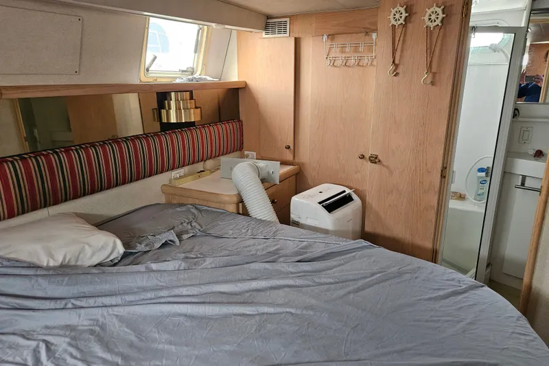 Slide: The Image of Interior of 1993 Silverton 46 Motor Yacht bedroom with bed, window, and bathroom. - 38