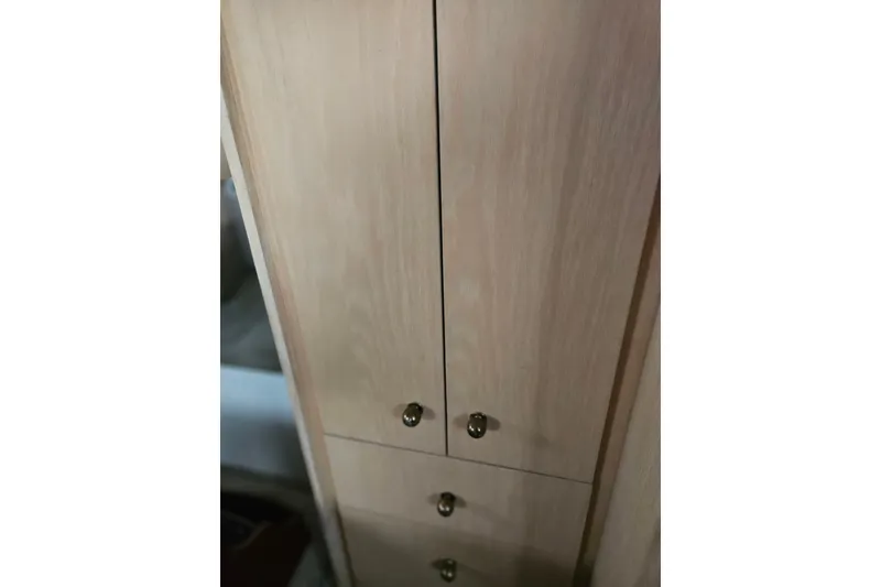 Slide: The Image of Wooden cabinet with brass knobs inside a 1993 Silverton 46 Motor Yacht. - 34