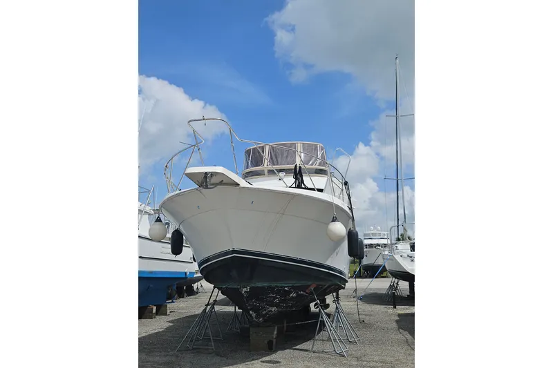 Slide: The Image of 1993 Silverton 46 Motor Yacht on stands under a clear blue sky. - 58