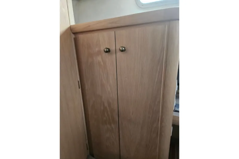 Slide: The Image of Wooden cabinet inside 1993 Silverton 46 Motor Yacht, featuring brass knobs. - 35