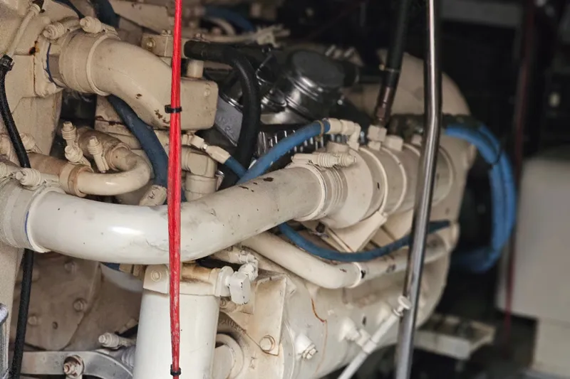 Slide: The Image of Engine compartment of a 1993 Silverton 46 Motor Yacht with visible pipes and hoses. - 49