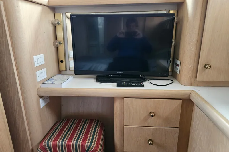 Slide: The Image of Interior of 1993 Silverton 46 Motor Yacht with TV and wooden cabinetry. - 43