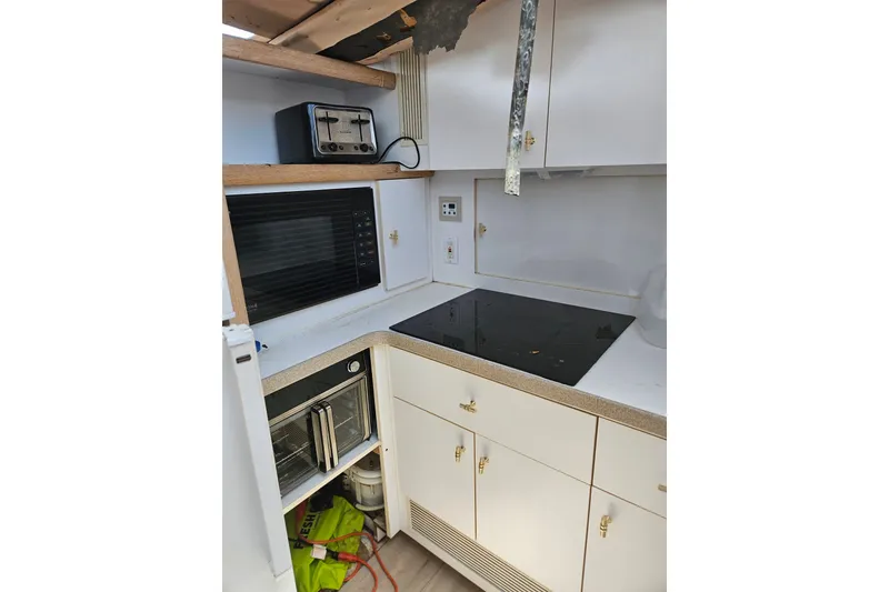 Slide: The Image of 1993 Silverton 46 Motor Yacht kitchen with stove, microwave, and toaster. - 28