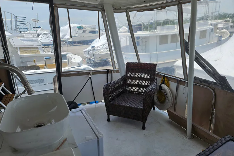 Slide: The Image of 1993 Silverton 46 Motor Yacht interior with wicker chair and marina view. - 18