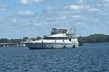 The Image of A 1993 Silverton 46 Motor Yacht on calm water under a blue sky. - 1