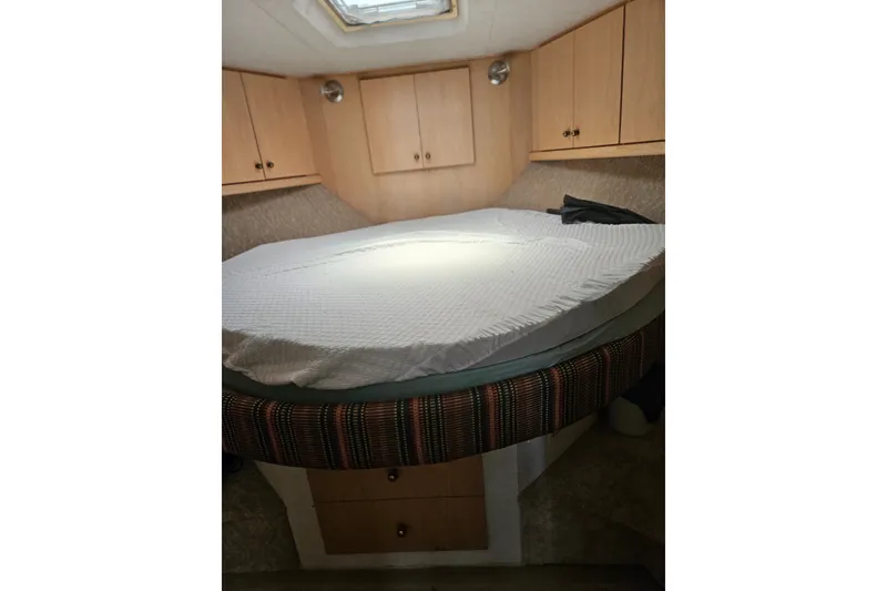 Slide: The Image of Cozy bedroom interior of 1993 Silverton 46 Motor Yacht with wooden cabinets and round bed. - 21