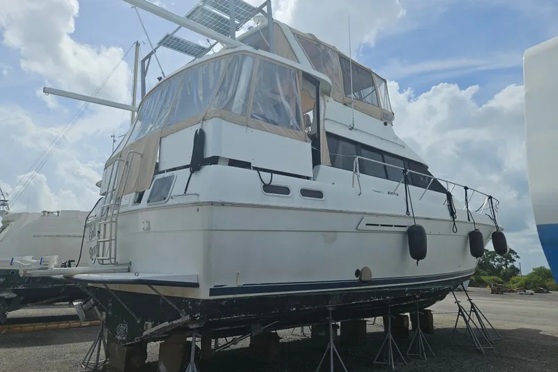 Slide: The Image of 1993 Silverton 46 Motor Yacht on dry dock under a cloudy sky. - 56