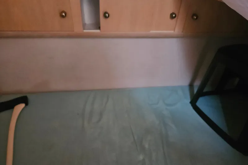 Slide: The Image of Interior of 1993 Silverton 46 Motor Yacht with wooden cabinets and blue bedding. - 24