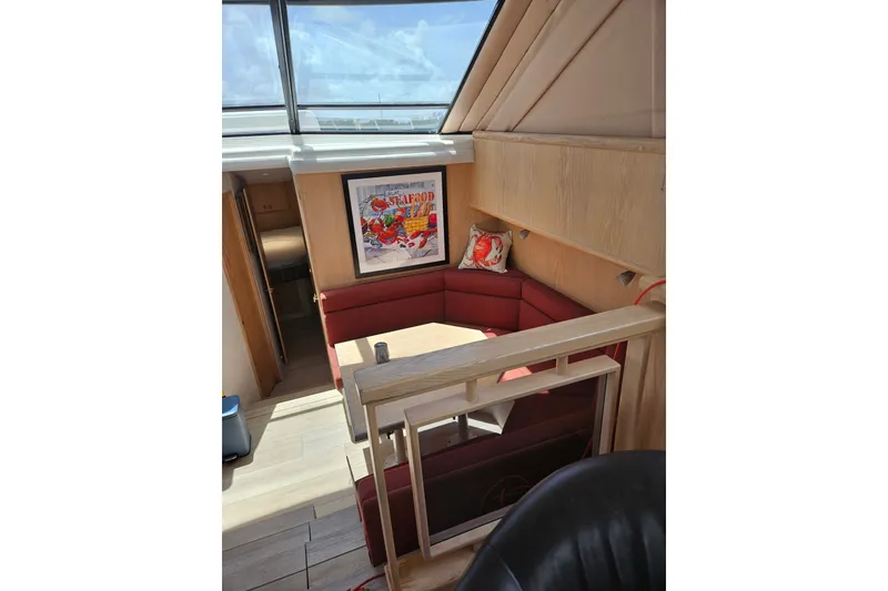 Slide: The Image of Interior of 1993 Silverton 46 Motor Yacht with red seating and seafood artwork. - 26