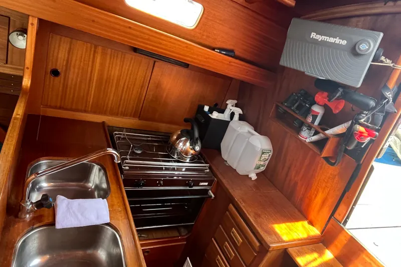 Slide: The Image of Interior of 1984 Vindo 34 sailboat with wooden cabinetry and kitchen amenities. - 6