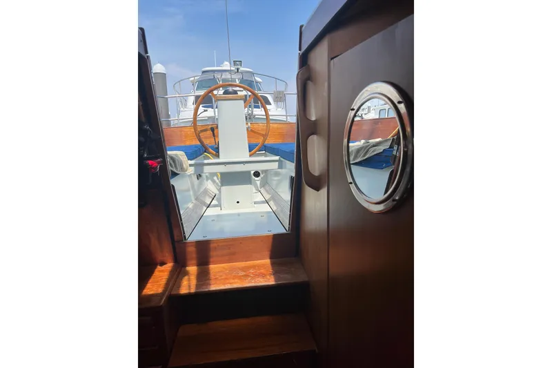 Slide: The Image of Interior view of 1984 Vindo 34 sailboat, showcasing wooden cabin and steering wheel. - 2