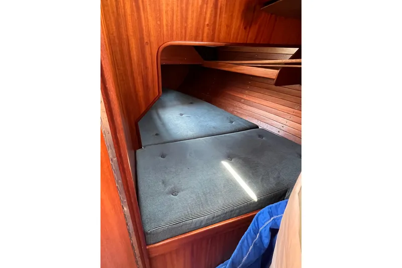 Slide: The Image of Cozy cabin interior of 1984 Vindo 34 sailboat with wooden paneling and cushioned berth. - 8