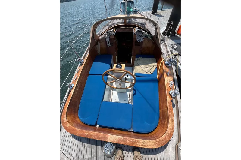 Slide: The Image of 1984 Vindo 34 sailboat cockpit with blue cushions and wooden steering wheel. - 3