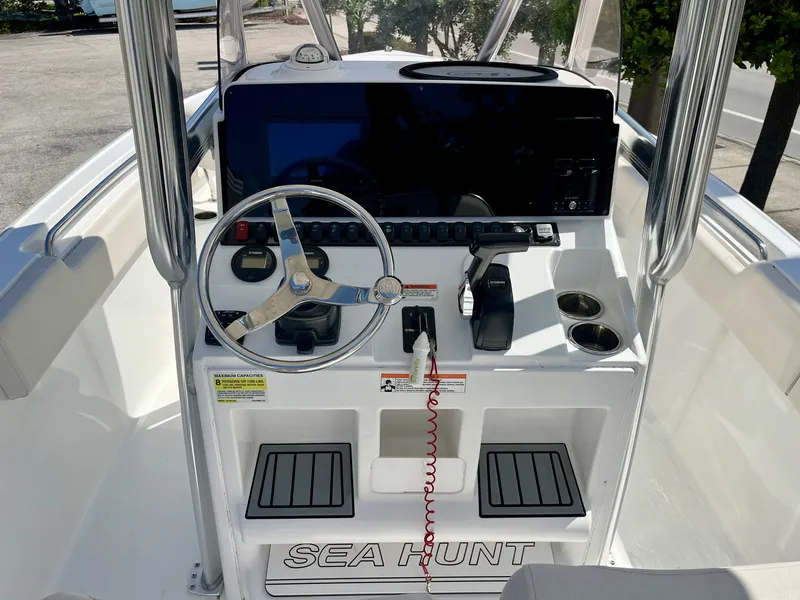 Slide: The Image of The image shows the helm of a 2022 Sea Hunt Ultra 234 boat with a modern steering wheel and controls. - 10