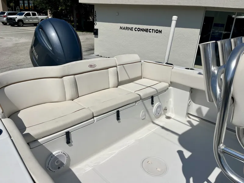 Slide: The Image of The image shows the cockpit of a 2022 Sea Hunt Ultra 234 boat with white upholstery. - 21