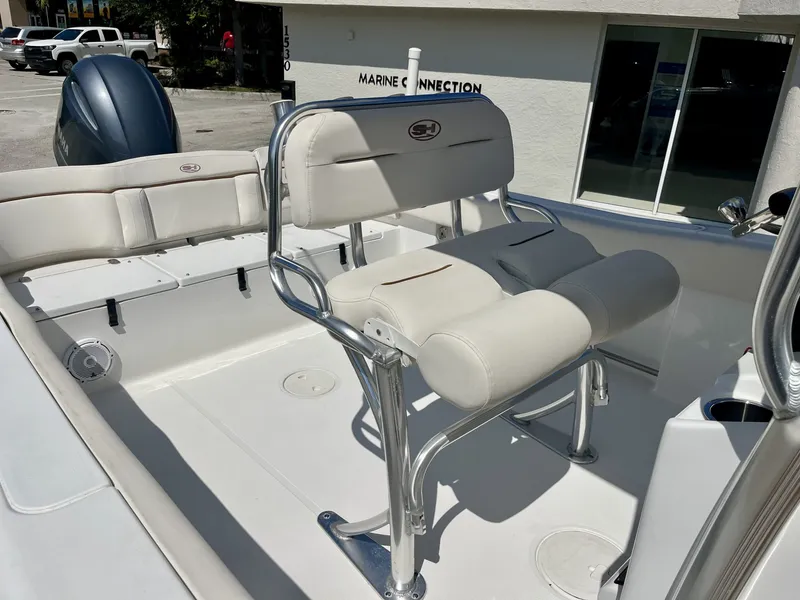 Slide: The Image of The image shows the helm area of a 2022 Sea Hunt Ultra 234 boat with beige seating. - 19