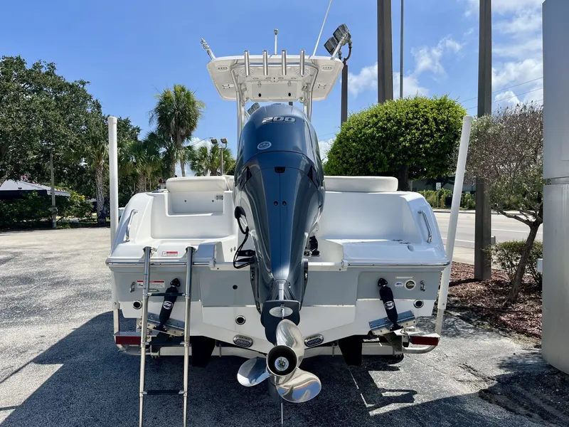 Slide: The Image of A 2022 Sea Hunt Ultra 234 boat with a large outboard motor, parked on a lot. - 5