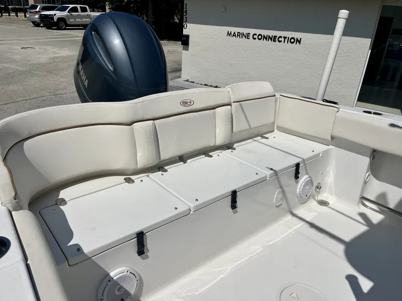 Slide: The Image of The image shows the stern of a 2022 Sea Hunt Ultra 234 boat with white upholstery and a Yamaha engine. - 20
