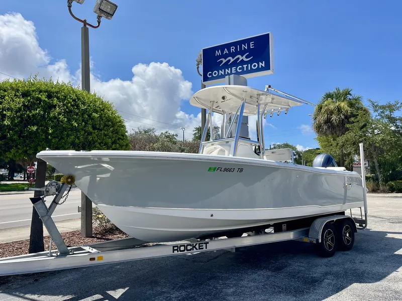 Slide: The Image of A 2022 Sea Hunt Ultra 234 boat on a trailer in front of a Marine Connection sign. - 2
