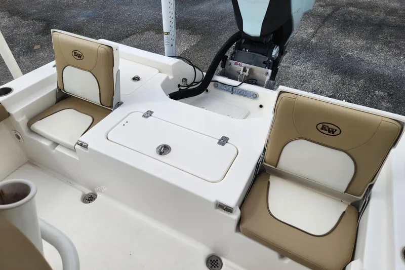 Slide: The Image of 2019 Key West 230 Bay Reef boat interior with tan seating and storage compartments. - 16
