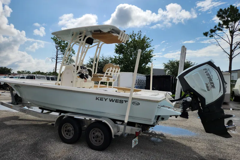 Slide: The Image of 2019 Key West 230 Bay Reef boat on trailer with Evinrude engine, parked outdoors. - 4