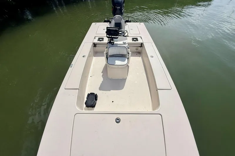 Slide: The Image of 2007 Hewes Redfisher 21 boat on calm water, featuring a central console and seating. - 19