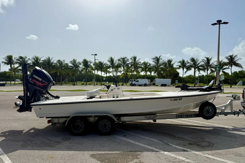 Slide: The Image of 2007 Hewes Redfisher 21 boat on trailer, parked near palm trees under a sunny sky. - 25
