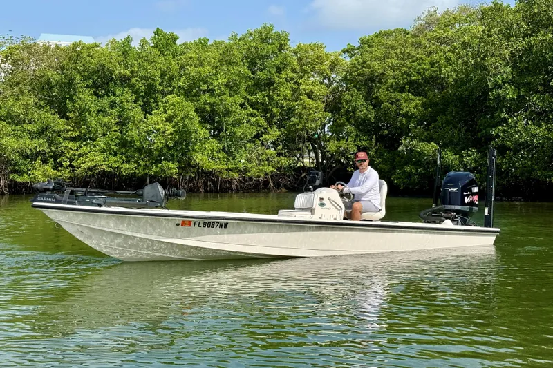 The Image of 2007 Hewes Redfisher 21 boat on calm water, surrounded by lush greenery. - 0