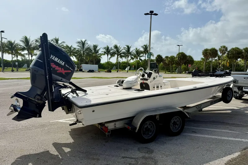 Slide: The Image of 2007 Hewes Redfisher 21 boat on trailer with Yamaha engine, parked near palm trees. - 24