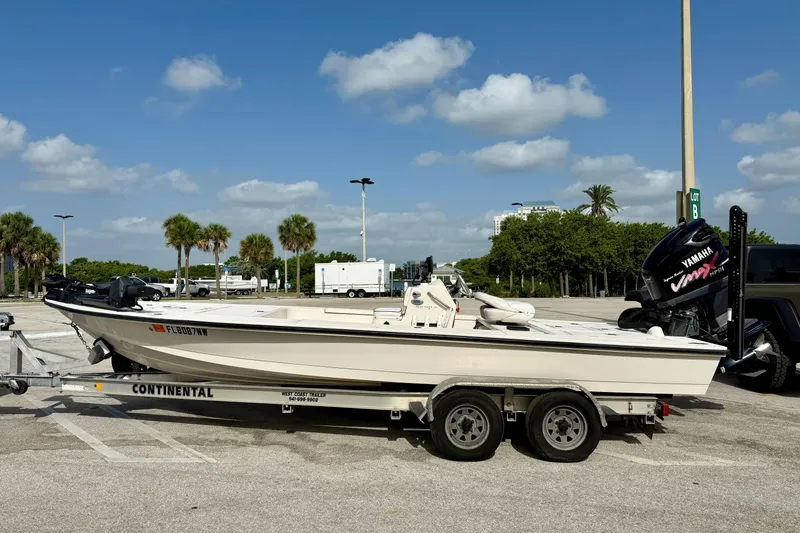 Slide: The Image of 2007 Hewes Redfisher 21 boat on trailer, parked outdoors under a clear blue sky. - 22