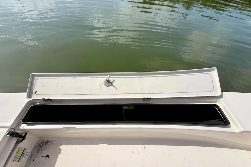 Slide: The Image of Open storage compartment on a 2007 Hewes Redfisher 21 boat, near calm water. - 18