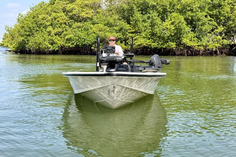 Slide: The Image of 2007 Hewes Redfisher 21 boat navigating calm waters near lush mangroves. - 2