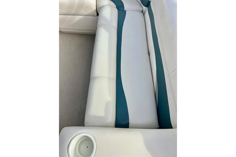 Slide: The Image of Sun Tracker Party Barge 20 Classic Series 2010 boat seating with cup holder, white and teal upholstery. - 23