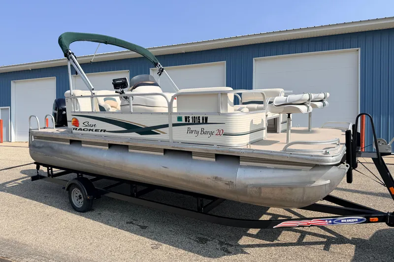 Slide: The Image of 2010 Sun Tracker Party Barge 20 Classic Series pontoon boat on trailer, parked by blue building. - 36