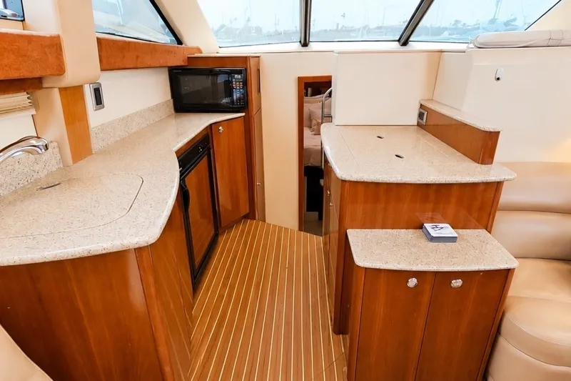 Slide: The Image of 2007 Meridian 341 Sedan yacht interior with wood cabinetry, kitchenette, and modern amenities. - 5