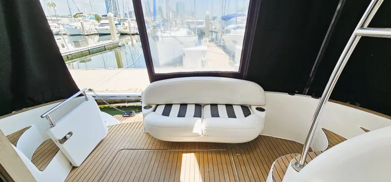Slide: The Image of 2007 Meridian 341 Sedan yacht interior with white seating and wooden flooring at a marina. - 13
