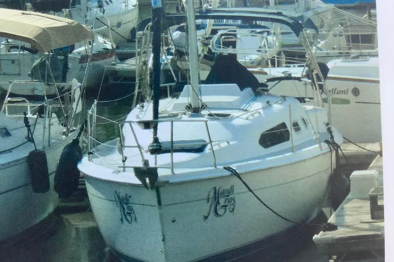 Slide: The Image of 2003 Hunter 306 sailboat docked in a marina, surrounded by other boats. - 8